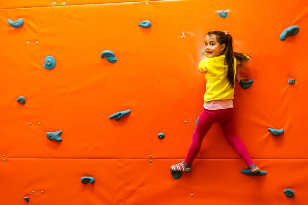 istock Girl climbing on a wall in attraction playground 1135050361