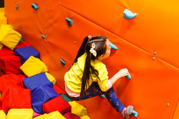 istock Girl climbing on a wall in attraction playground 1135050422