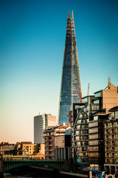 Color image depicting the modern architecture on the South Bank in London, UK. Futuristic buildings and restaurants abound, with people walking along the Thames path. In the distance The Shard, the tallest building in western Europe, looms over the city. Room for copy space.