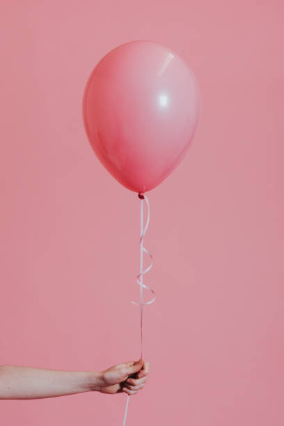 istock Girl with a pink helium balloon 1135058023