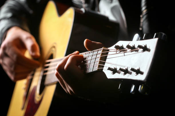 istock Young men playing the guitar with black background 1135059409