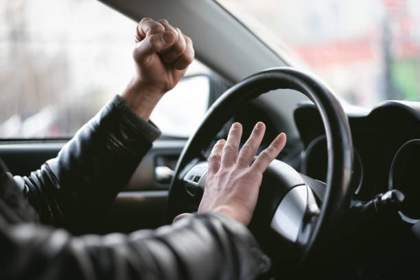 Angry driver. Angry driver is honking and is yelling by sitting of a steering wheel. Road aggression concept. Traffic jam. displeased stock pictures, royalty-free photos & images