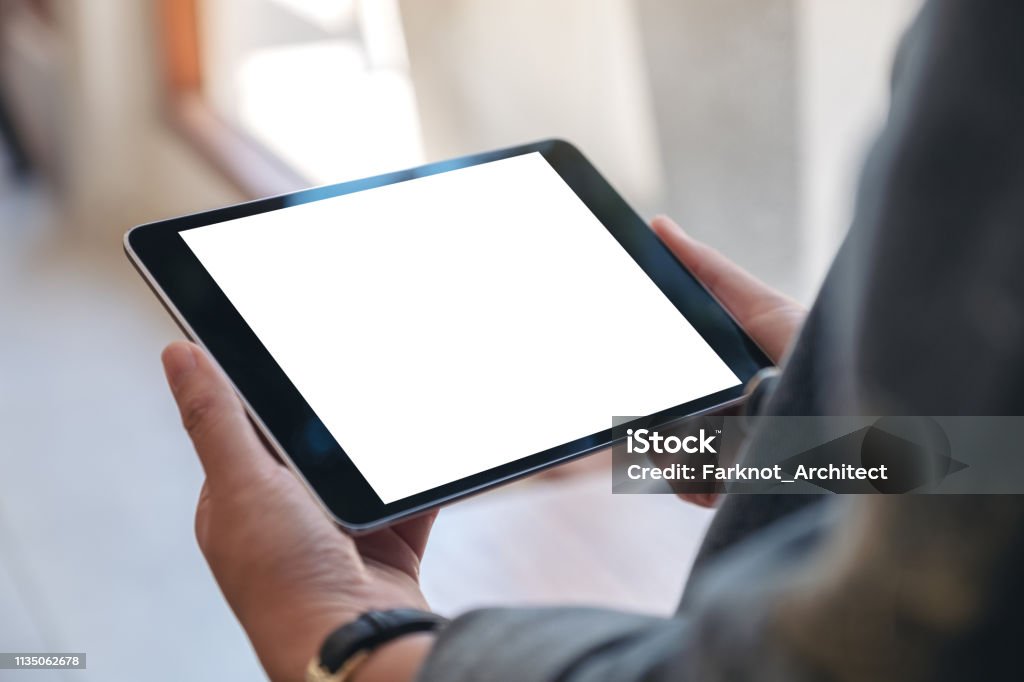カフェで水平に空白の画面を持つ黒いタブレット pc を保持している女性の手のモックアップイメージ - タブレット端末のロイヤリティフリーストックフォト