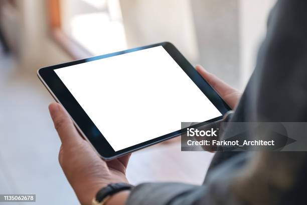 Mockup Image Of Womans Hands Holding Black Tablet Pc With Blank Screen Horizontally In Cafe Stock Photo - Download Image Now