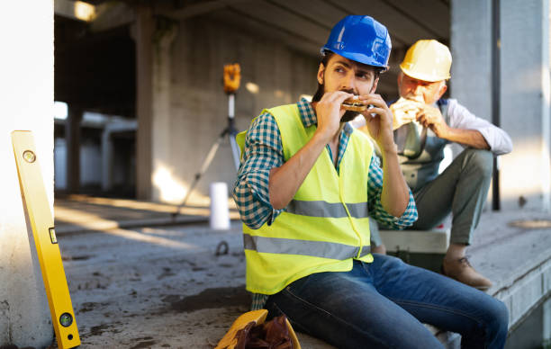 istock Happy mature and young engineer, architect, worker sitting at building site and resting 1135064464