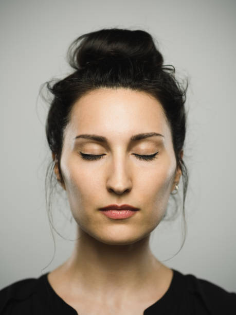 Studio portrait of real mediterranean young woman with eyes closed stock photo