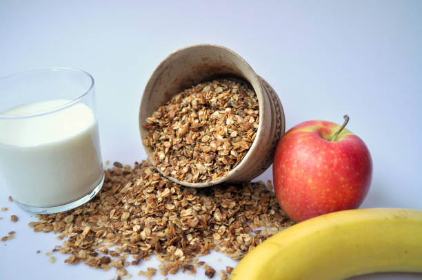 istock granola in a wooden container on a white background with milk and fruit 1135066608