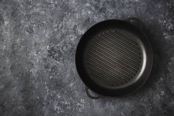 Empty round old grill pan dark stone background top view