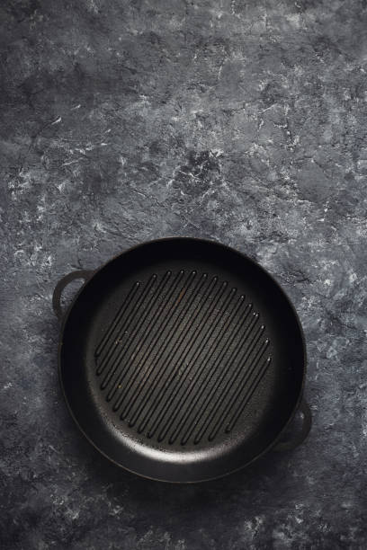 istock Empty round old grill pan dark stone background top view 1135066792