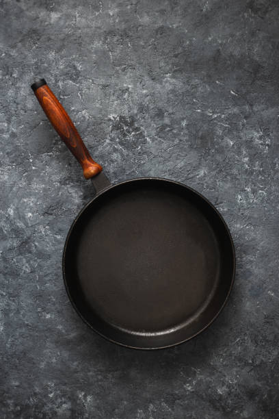 istock Empty round pan wooden handle dark stone background top view 1135066820
