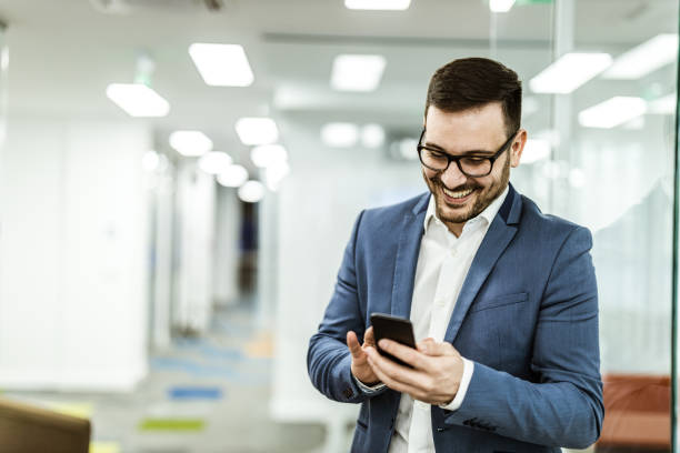 istock Young happy businessman text messaging on cell phone. 1135066837