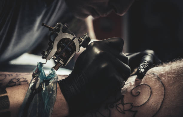 istock Tattoo master making tattoo on leg 1135066866
