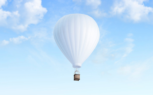 Colorful hot air balloon with rainbow color soaring in the sky,cloud with blue sky in the background,view from low angle