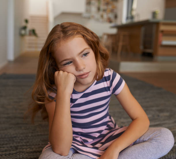 Shot of a little girl looking bored at home