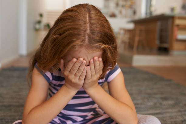 Something's bothering her Shot of a little girl covering her face at home little redhead girl stock pictures, royalty-free photos & images