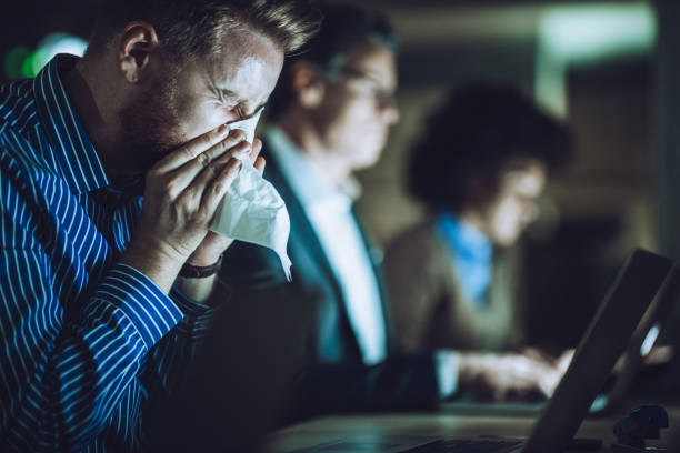 istock Ill businessman blowing nose while working late in the office. 1135068567