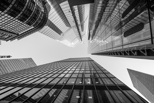 Highly detailed abstract wide angle view up towards the sky in the financial district of London City and its ultra modern contemporary architecture. Shot on Canon EOS R full frame system with 14mm wide prime lens. Monochrome edit in Black and White image with high contrast.