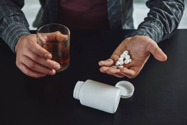istock You largely constructed your depression. It wasn't given to you. Therefore, you can deconstruct it. Close up of man sitting at table with alcohol and drugs. Alcoholism concept 1135070368
