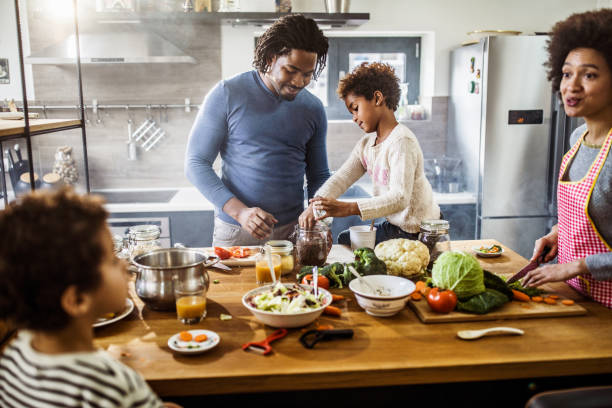 istock Happy African American family cooperating while preparing meal in the kitchen. 1135071270