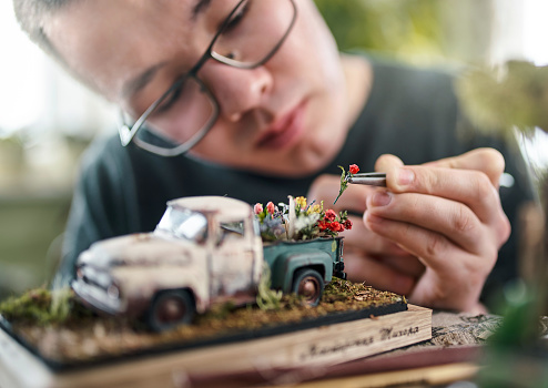 Hombre joven haciendo miniatura Vintage modelo de camioneta photo