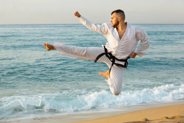 istock Guy doing karate poses at  sunset sea shore 1135072302