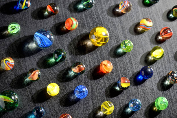 istock Glass marble balls and shadows on black table 1135072305