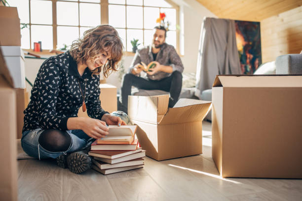 istock Young couple sitting in new apartment around unpacked boxes 1135072984