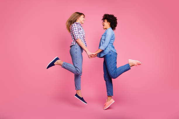 istock Full length body size profile side view of two person nice-looking attractive charming cheerful cheery girls rejoicing holding hands isolated over pink pastel background 1135073544