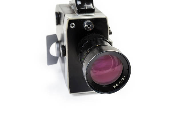 Super 8-mm amateur mechanical movie camera close-up Old Super 8-mm format amateur film movie camera powered by clockwork motor on a white background. View from the side of the lens close-up at selective focus vintage amateur movie camera stock pictures, royalty-free photos & images