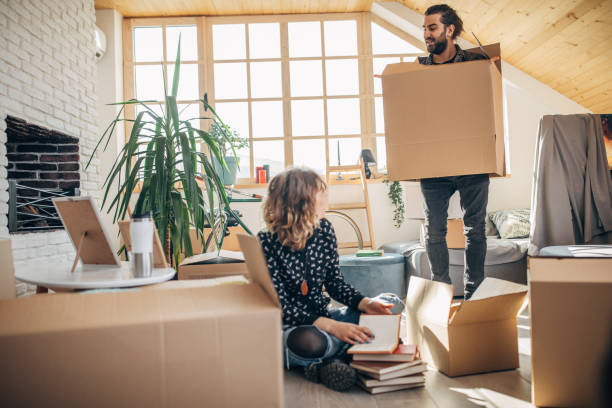 istock Couple having fun in new apartment around unpacked boxes 1135075432