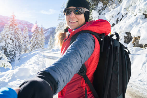 istock woman hiking in winter turning back to camera 1135077450