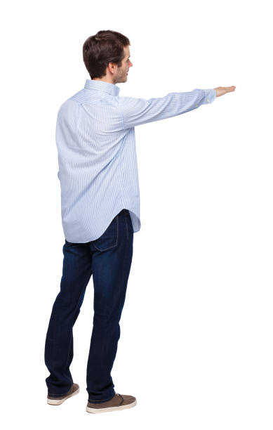 istock Back view of a man in jeans points his hand upwards. 1135078216