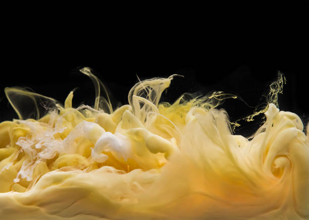 Coloured acrylic ink mixing in water isolated on black background. Abstract art background. Creamy vanilla and caramel mixed together