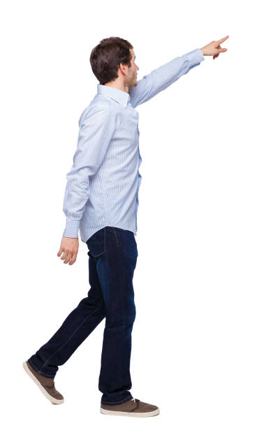 istock Back view of a man walking with a pointing hand. 1135078615