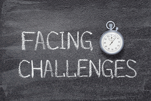facing challenges phrase written on chalkboard with vintage precise stopwatch