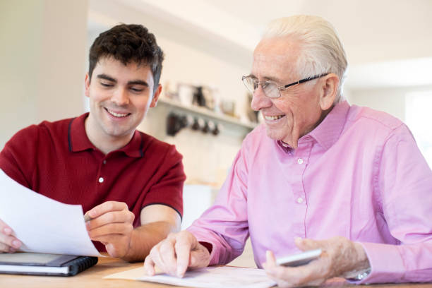 istock Young Man Helping Senior Neighbor With Paperwork At Home 1135080690