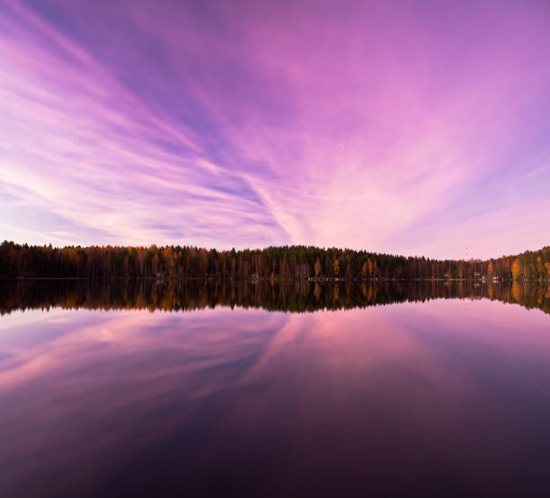 Pink clouds at night reflecting from lake in Finland