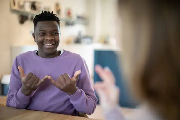 Teenage Boy And Girl Having Conversation Using Sign Language