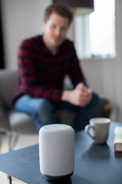 istock Man In  Lounge At Home Asking Digital Assistant Question 1135081031