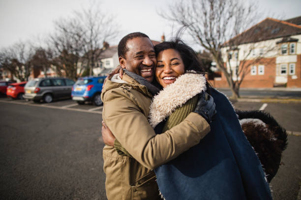 A Loving hug A father embracing his daughter in the street with a hug. northern europe family car stock pictures, royalty-free photos & images