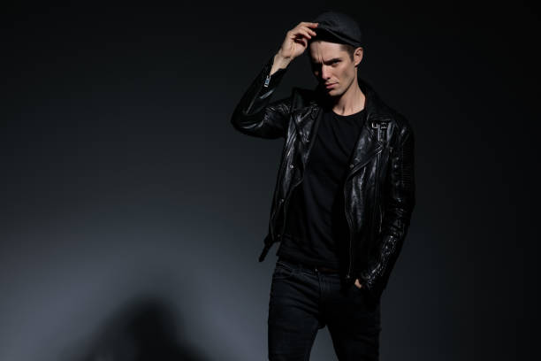 istock serious fashion man in leather jacket adjusting his hat 1135086447