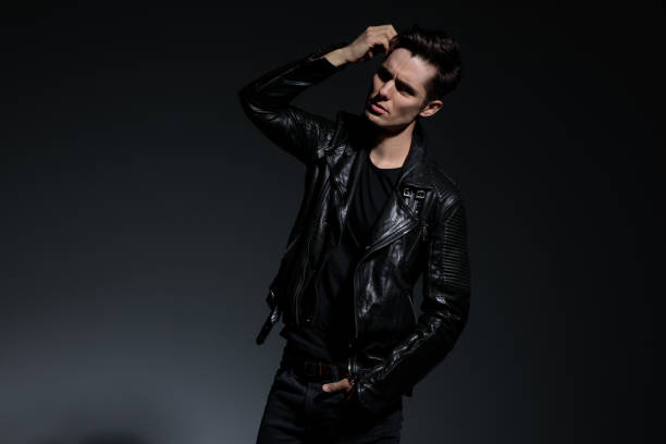 istock dramatic young man in leather jacket fixes his hairstyle 1135086727