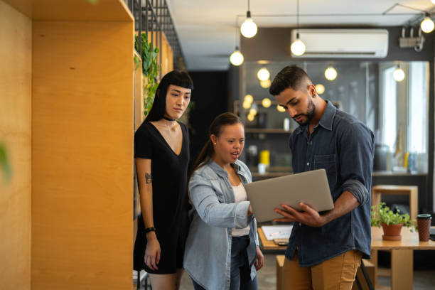 istock Business people (including Special Needs Woman) walking through office lobby and discussing new project 1135086951