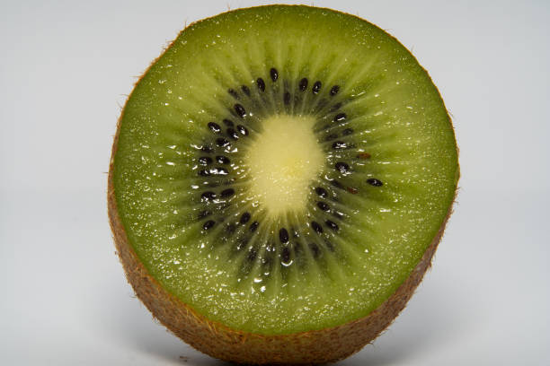 istock Close up Green kiwi fruit cut in half with with a shadow on the bottom. 1135086967