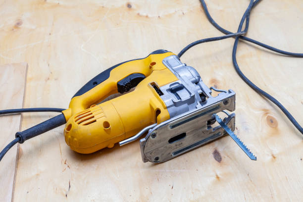 istock A yellow electric jigsaw ready for work use on the workbench with sawn plywood in a workshop for carpentry work. Tool for industry and production. 1135087884