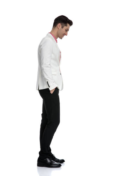 istock smiling man standing with hands in pockets and looks down 1135087895
