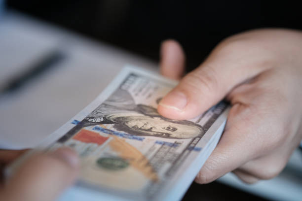 istock businessmen corruption. Man giving bribe money. 1135088010
