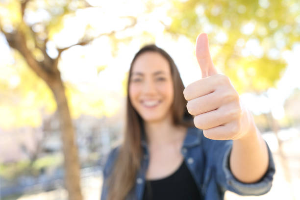 istock Happy woman gesturing thumb up in a park 1135088576