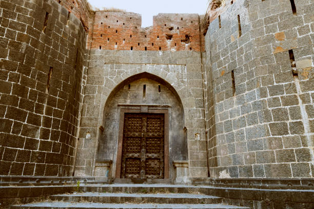 stone masonry wall and main gate with heavy-duty door at sardar purandare wada, saswad, pune - maratha imagens e fotografias de stock