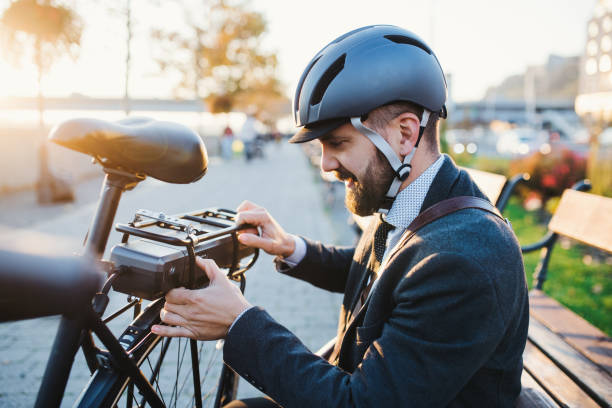 都会の電動自転車を設定するヒップスターのビジネスマン通勤。 - electric bicycle ストックフォトと画像